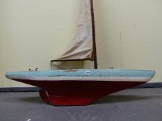 A LARGE POND YACHT IN BLUE, WHITE AND RED WITH PLANK DECK AND BRASS FITTINGS.