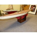AN EARLY 20th.C. POND YACHT, "VANITY", WHITE AND RED HULL, ALLOY DECK FITTINGS AND WEIGHTED KEEL, ON