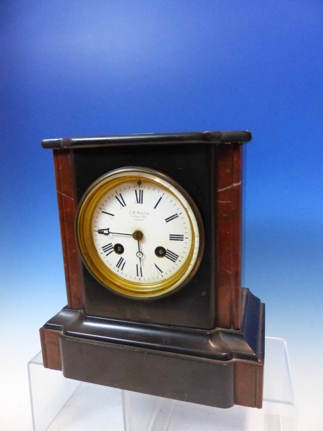 A BLACK SLATE CLOCK RETAILED BY J W BENSON NAMED ON THE DIAL BETWEEN TWO RED STONE COLUMNS AND ON