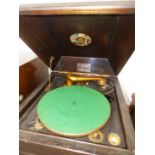 AN OAK CASED CLIFTOPHONE WIND UP GRAMOPHONE, THE GREEN BAIZE TOPPED TURNTABLE ABOVE DOORS OPENING TO