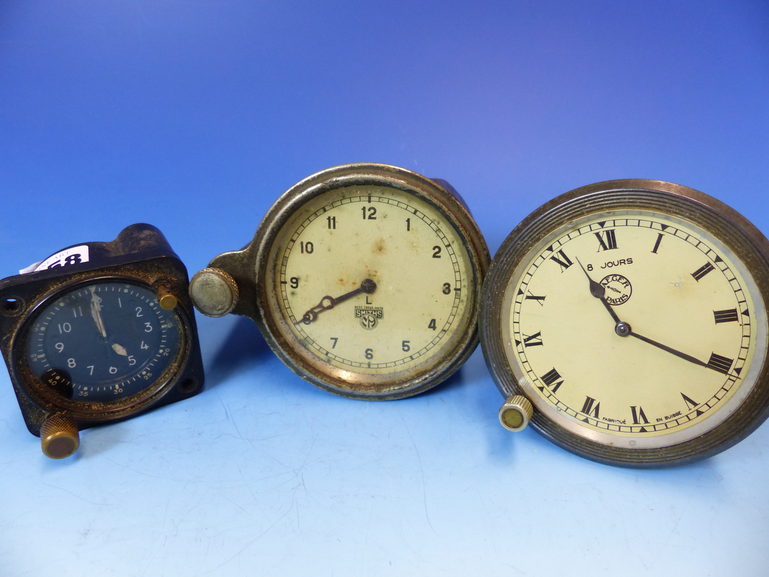 THREE CAR CLOCKS, ONE BY JAEGER. Dia. 9.5cms. ANOTHER BY SMITHS, Dia. 9cms. THE LAST IN BLACKENED