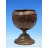 A COCONUT CUP WITH WHITE METAL RIM AND SUPPORTED ON STEPPED CIRCULAR COPPER FOOT. H 13cms.