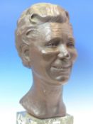 LOUISA BOLT, 1971, A BRONZE HEAD OF A SMILING LADY SUPPORTED ON VARIEGATED GREEN STONE PLINTH. H
