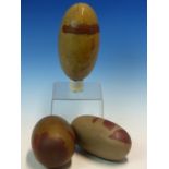 A COLLECTION OF THREE INDIAN RIVER POLISHED OATMEAL AND LIVER RED LINGAM STONES, THE LARGEST. W