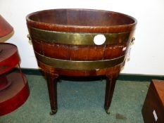 A GEOIII MAHOGANY AND BRASS BOUND OVAL WINE COLLER ON STAND.