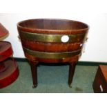 A GEOIII MAHOGANY AND BRASS BOUND OVAL WINE COLLER ON STAND.