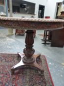 A COLONIAL HARD WOOD CIRCULAR TABLE WITH GADROONED RIM AND FOLIATE RELIEF CARVED APRON, THE CARVED