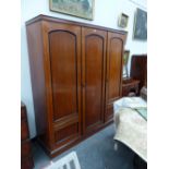 A HOWARD AND SONS VICTORIAN FRUITWOOD TRIPLE COMPACTUM WARDROBE, EBONISED MOULDINGS. H 196 x W