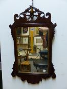 AN ANTIQUE MAHOGANY FRET CUT FRAME WALL MIRROR WITH HO-HO BIRD CREST. 76 x 44cms.