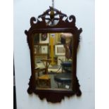 AN ANTIQUE MAHOGANY FRET CUT FRAME WALL MIRROR WITH HO-HO BIRD CREST. 76 x 44cms.