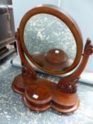 A VICTORIAN SWING MIRROR ON CARVED SUPPORTS.