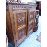 A HAND MADE GOTHIC REVIVAL CARVED OAK SIDE CABINET WITH LINEN FOLD SIDE PANELS AND CARVED WITH