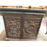 AN OAK TABLE TOP CABINET, THE DRAGON CARVED DOORS OPENING TO REVEAL THREE PIGEON HOLES EACH ABOVE