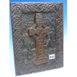 AN IRISH CARVED OAK PANEL DEPICTING A CELTIC CROSS IN THE GRAVE YARD OF A RUINED CHURCH FRAMED BY