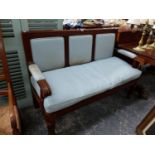 A VICTORIAN MAHOGANY SHOW FRAME HALL SETTLE WITH UPHOLSTERED PANEL BACK STANDING ON TURNED REEDED