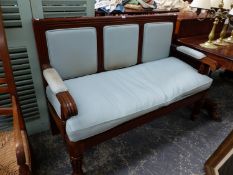 A VICTORIAN MAHOGANY SHOW FRAME HALL SETTLE WITH UPHOLSTERED PANEL BACK STANDING ON TURNED REEDED