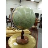 A TERRESTIAL GLOBE WITH AN ALUMINIUM ARC TO ONE SIDE MARKED WITH A 90 DEGREE SCALE ABOVE A WOODEN