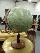 A TERRESTIAL GLOBE WITH AN ALUMINIUM ARC TO ONE SIDE MARKED WITH A 90 DEGREE SCALE ABOVE A WOODEN