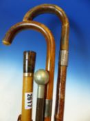 A WALKING CANE MOUNTED WITH A 9CT GOLD BAND, TWO WALKING STICKS WITH SILVER BANDS AND A SWAGGER