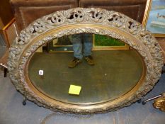 ANTIQUE PIERCED GILT FLORENTINE STYLE OVAL MIRROR. H. 99 x W. 84cms.