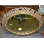 ANTIQUE PIERCED GILT FLORENTINE STYLE OVAL MIRROR. H. 99 x W. 84cms.