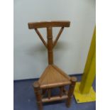 A PINE TURNER'S CHAIR, THE BOWED TOP RAIL ON TURNED COLUMN ABOVE THE TRIANGULAR SEAT.