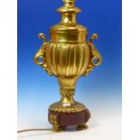 A FRENCH GILT BRONZE LAMP BASE OF BALUSTER SHAPE, THE FLUTED BODY WITH LEAF HANDLES AND THE RED