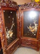 A LARGE LATE VICTORIAN ORIENTAL CARVED TWO FOLD SCREEN WITH IVORY AND LACQUER PANELS. EACH PANEL,