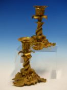 A PAIR OF ROCOCO BRONZE CANDLESTICKS, THE NOZZLES SUPPORTED ON THREE INTERTWINED DOLPHINS, EACH OF