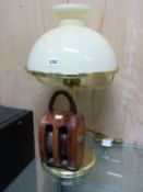 A BRASS TABLE LAMP MOUNTED WITH A WOODEN PULLEY AT ITS BASE AND WITH A LEMON GLASS SHADE. H 61cms.