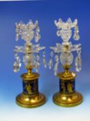 A PAIR OF TWO TIER LUSTRE CUT GLASS CANDLESTICKS ON CYLINDRICAL BLUE PORCELAIN BASES GILT WITH