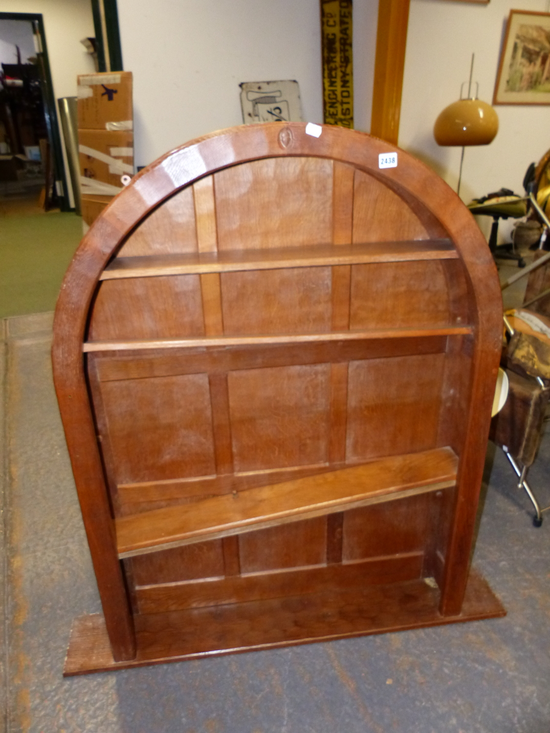 AN ARTS AND CRAFTS ACORN MAN OAK PANEL BACK ARCHED TOP BOOKCASE WITH ADZE FINISH. W.93 x D.17 x H.