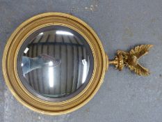 A CONVEX MIRROR WITHIN EBONISED SLIP, EAGLE TOPPED GILT CIRCULAR FRAME. H 105 x Dia. 65cms.