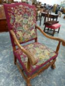 A 17th.C. TASTE CARVED BEECH ARMCHAIR WITH WINE RED GROUND FLORAL NEEDLEWORK BACK AND SEAT, THE LEAF