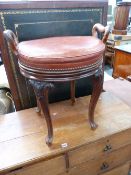 AN UNUSUAL VICTORIAN CARVED WALNUT REVOLVING MUSIC STOOL WITH TWIN SIDE HANDLES.