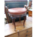 AN UNUSUAL VICTORIAN CARVED WALNUT REVOLVING MUSIC STOOL WITH TWIN SIDE HANDLES.