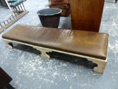 AN UNUSUAL BLEACHED ELM LEATHER SEAT HEARTH STOOL, HIGH BRACKET FEET. W. 160cms.