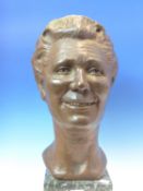 LOUISA BOLT, 1971, A BRONZE HEAD OF A SMILING LADY, ON GREEN MARBLE PLINTH. H 48.5cms.