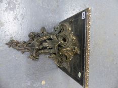 A CARVED WOOD AND GESSO ROCOCO FOLIAGE SUPPORTED SQUARE WALL BRACKET, NOW PAINTED BLACK WITH GILT