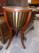 AN EDWARDIAN BRASS LINED MAHOGANY PLANTER WITH STRAP SIDES BELOW THE CIRCULAR TOP AND ON THREE