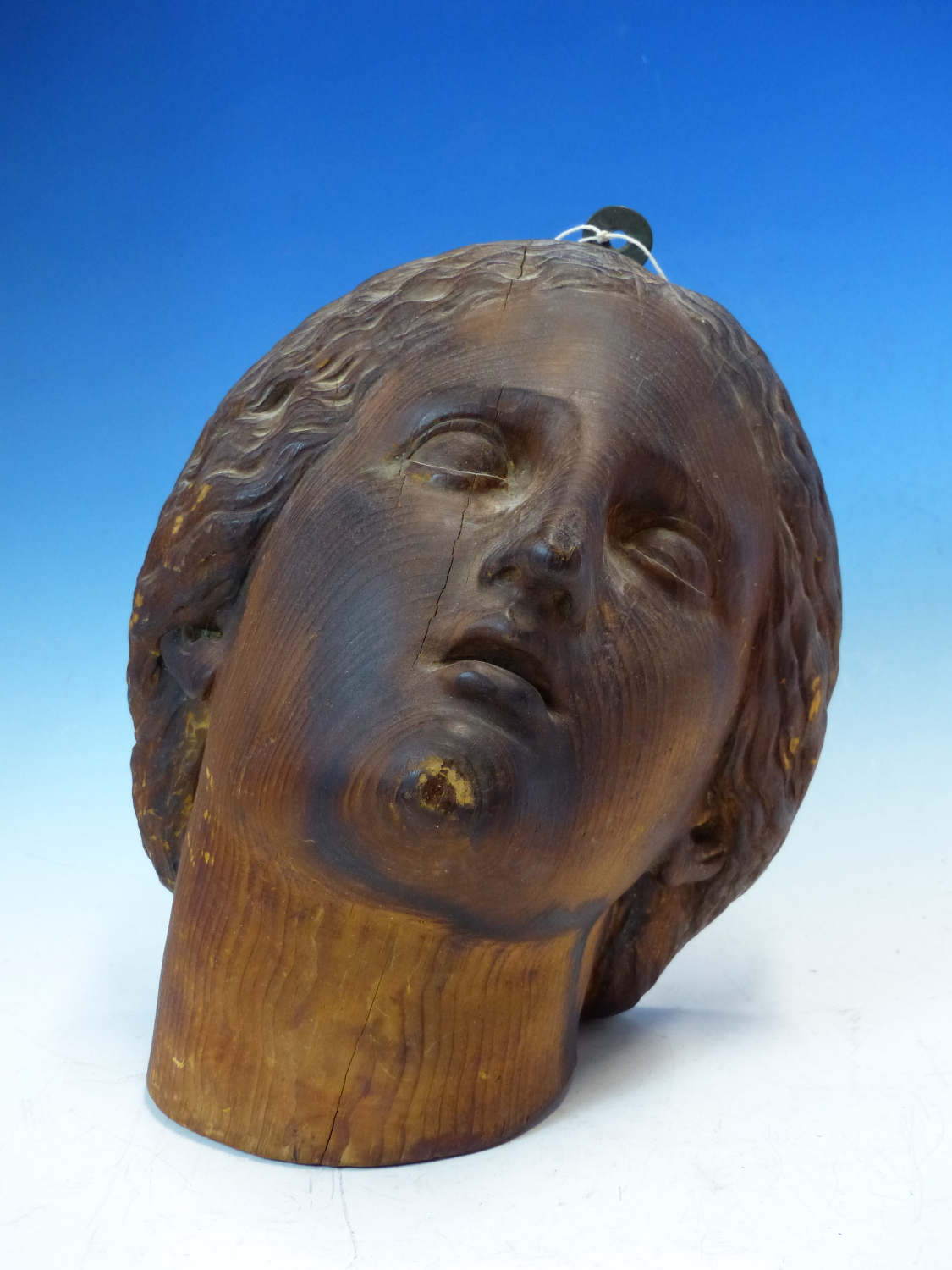 A CARVED PINE HEAD OF A FEMALE SAINT LOOKING HEAVENWARDS. H 26cms.