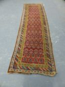 AN ANTIQUE TRIBAL CAUCASIAN RUNNER. 356 x 103cms.