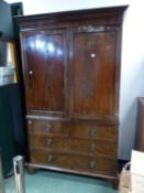 A LATE GEORGIAN MAHOGANY LINEN PRESS FITTED WITH FOUR SLIDES ENCLOSED BY PANEL DOORS OVER TWO