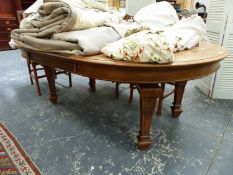 A LARGE VICTORIAN OAK WIND OUT EXTENDING DINING TABLE ON SQUARE TAPERED LEGS AND RECESSED CASTORS.