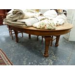 A LARGE VICTORIAN OAK WIND OUT EXTENDING DINING TABLE ON SQUARE TAPERED LEGS AND RECESSED CASTORS.