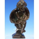 A 19th C. BRONZE FIGURE OF A SEATED CUPID, HIS WINGS WRAPPED BEHIND HIM LIKE A BILLOWING CLOAK, HE