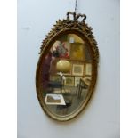 A GILT OVAL WALL MIRROR IN THE FRENCH TASTE. H. 72cms.