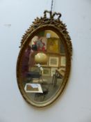 A GILT OVAL WALL MIRROR IN THE FRENCH TASTE. H. 72cms.