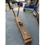 A MASSIVE WOODEN PLANE WITH TWO BLADES AND TWO SPOKE HANDLES TO ONE END. W 150cms.