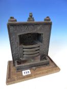 A SCARCE VICTORIAN CAST IRON MINIATURE SALESMAN'S SAMPLE OF A FIREPLACE HEARTH MOUNTED ON WOOD BASE.